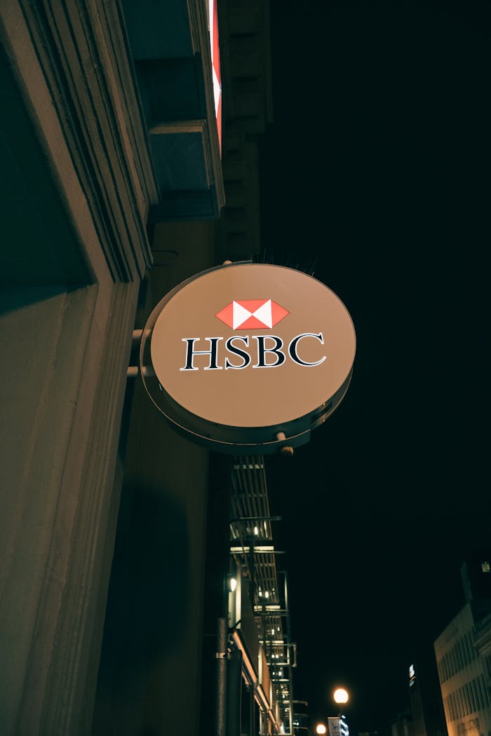Mastering the First Impression: Your intriguing post title goes here Vertical shot of an HSBC bank sign lit up at night, showcasing urban bank architecture.